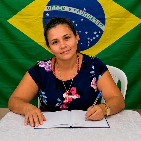 Aluna EJA escrevendo no caderno
